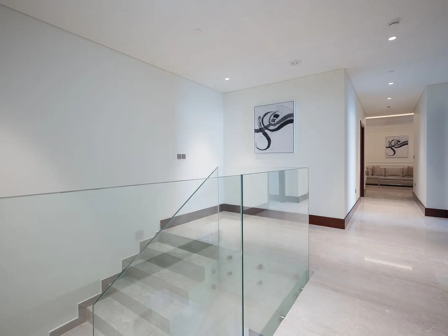 Clean hall leads down with glass and light