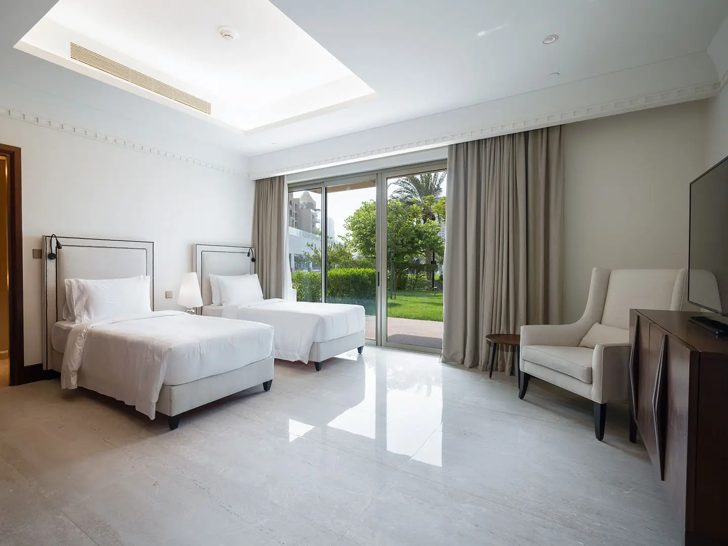 Bright bedroom with twin beds and garden view