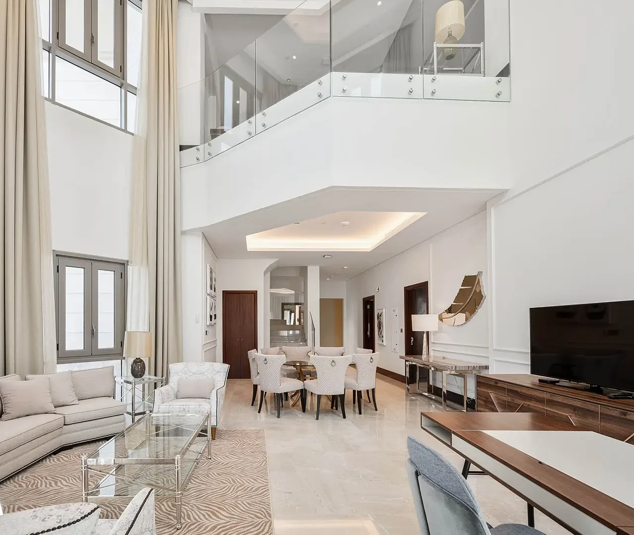 Bright living room with dining area and glass balcony