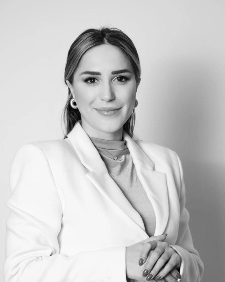 Professional woman in white blazer smiling confidently