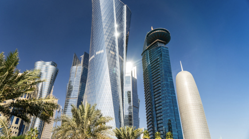 Modern skyscrapers under clear blue sky with palm trees
