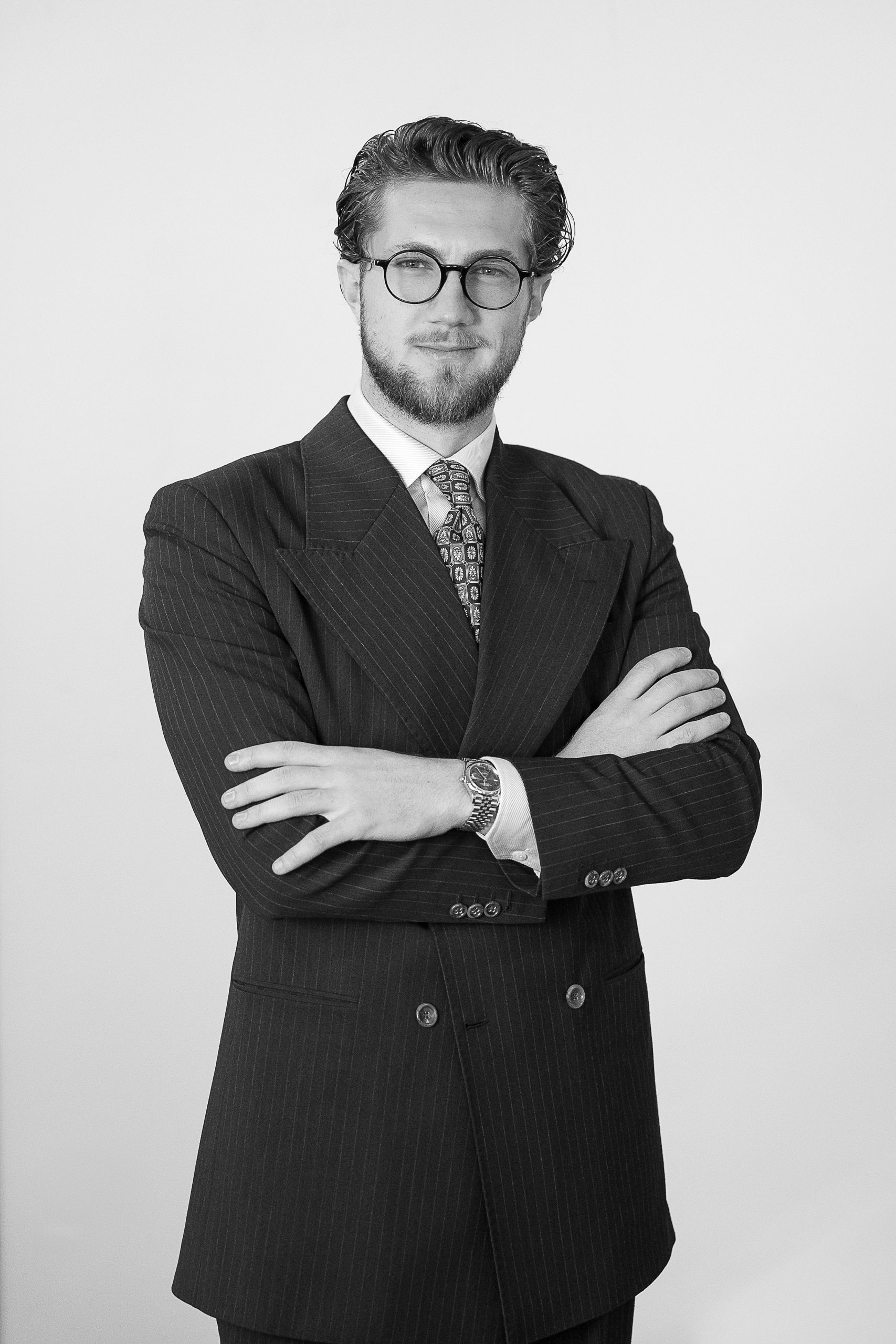 Professional man in suit standing indoors smiling