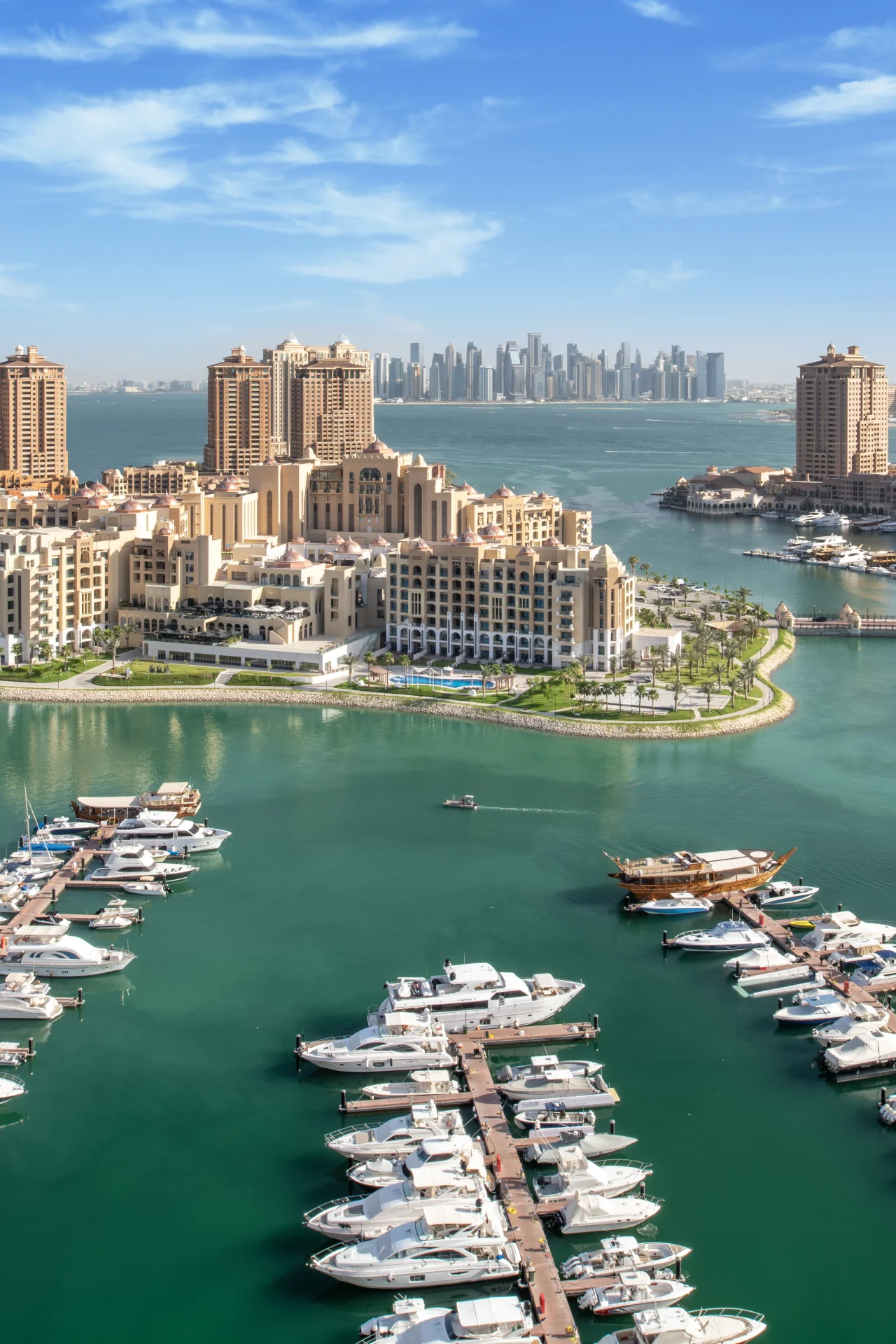 Luxury marina with yachts and waterfront buildings.