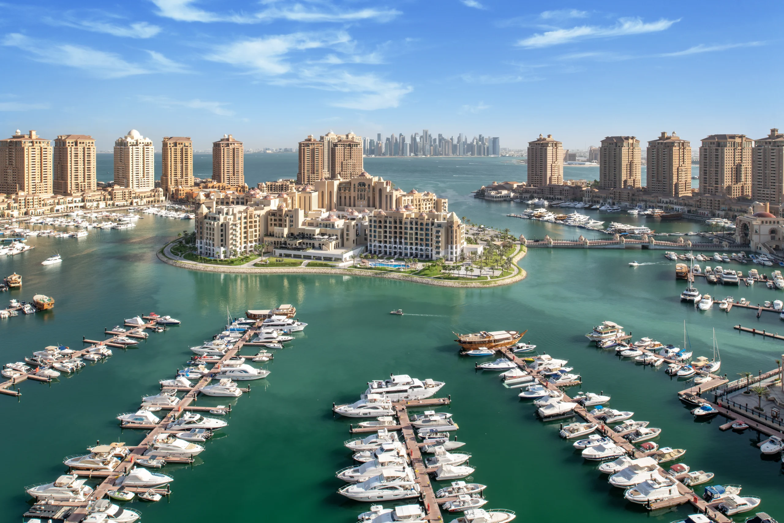 Luxury marina with yachts and waterfront buildings.