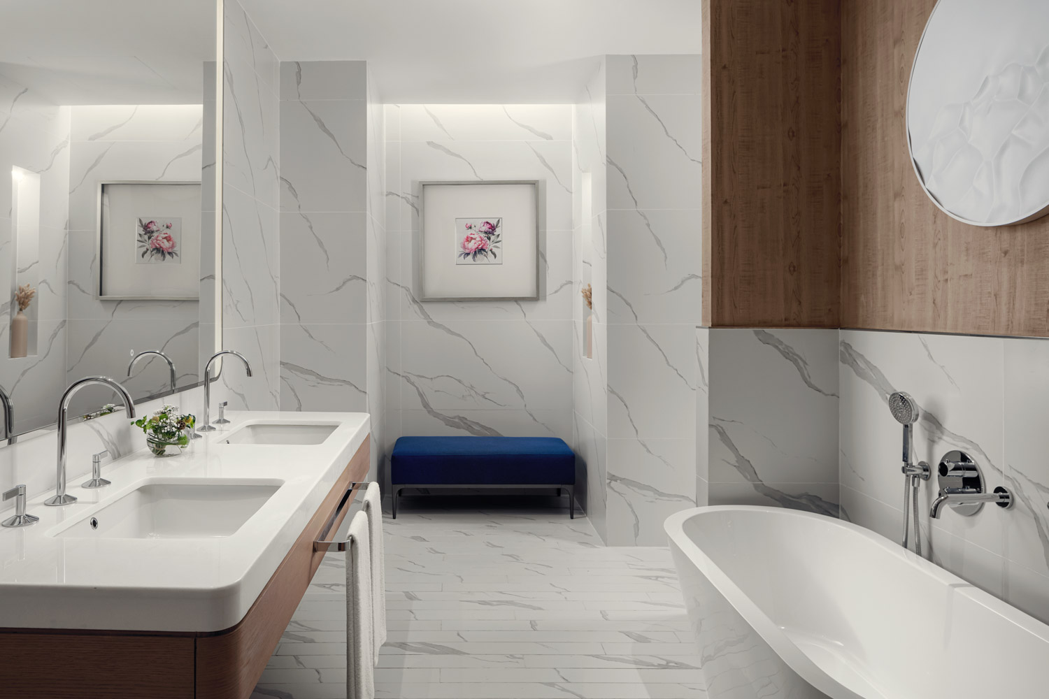 Modern bathroom with bathtub and double sinks.