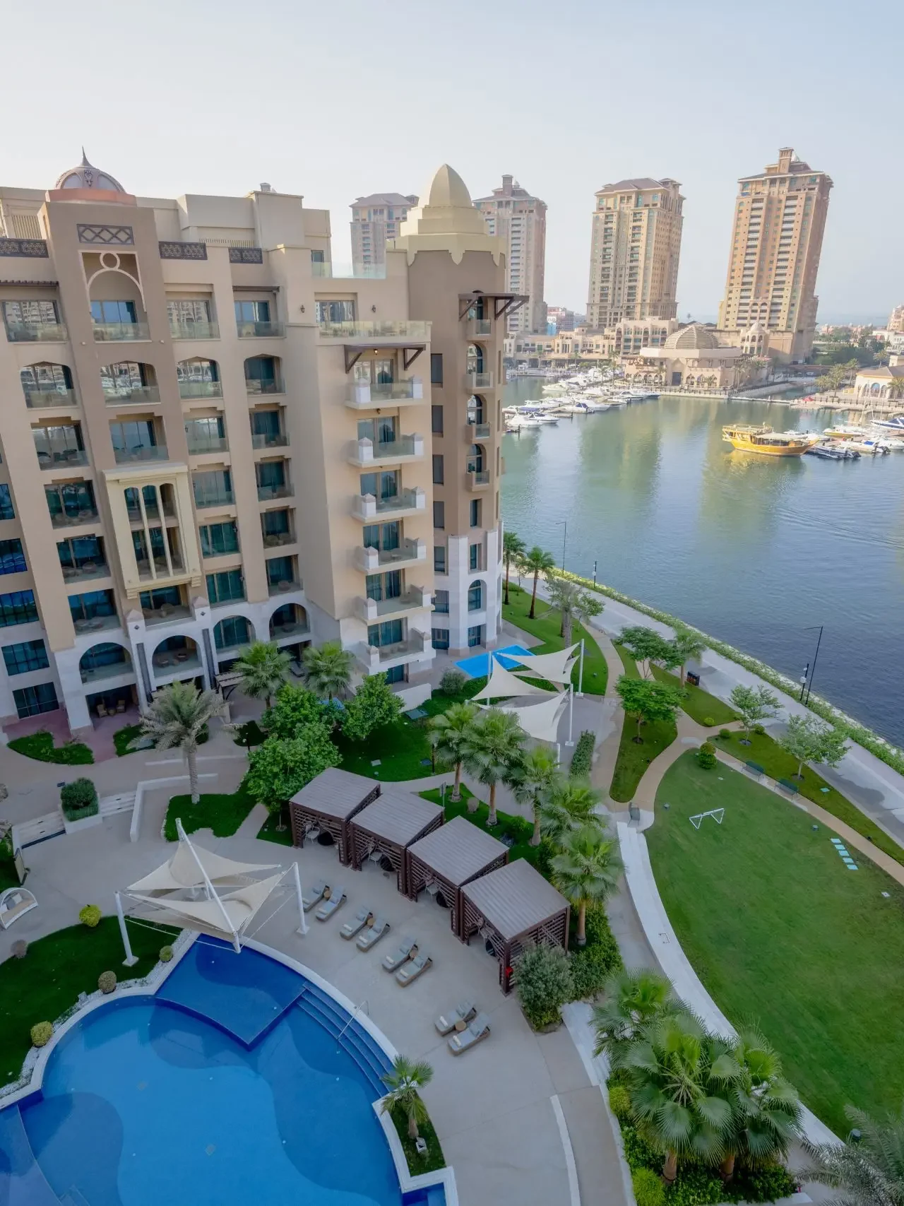 Luxury pool and marina view with garden and buildings