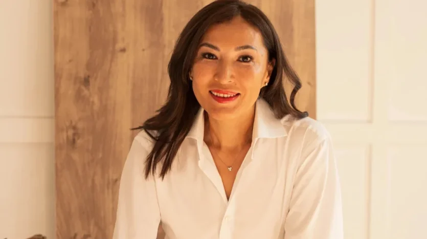 Smiling woman in white shirt posing indoors