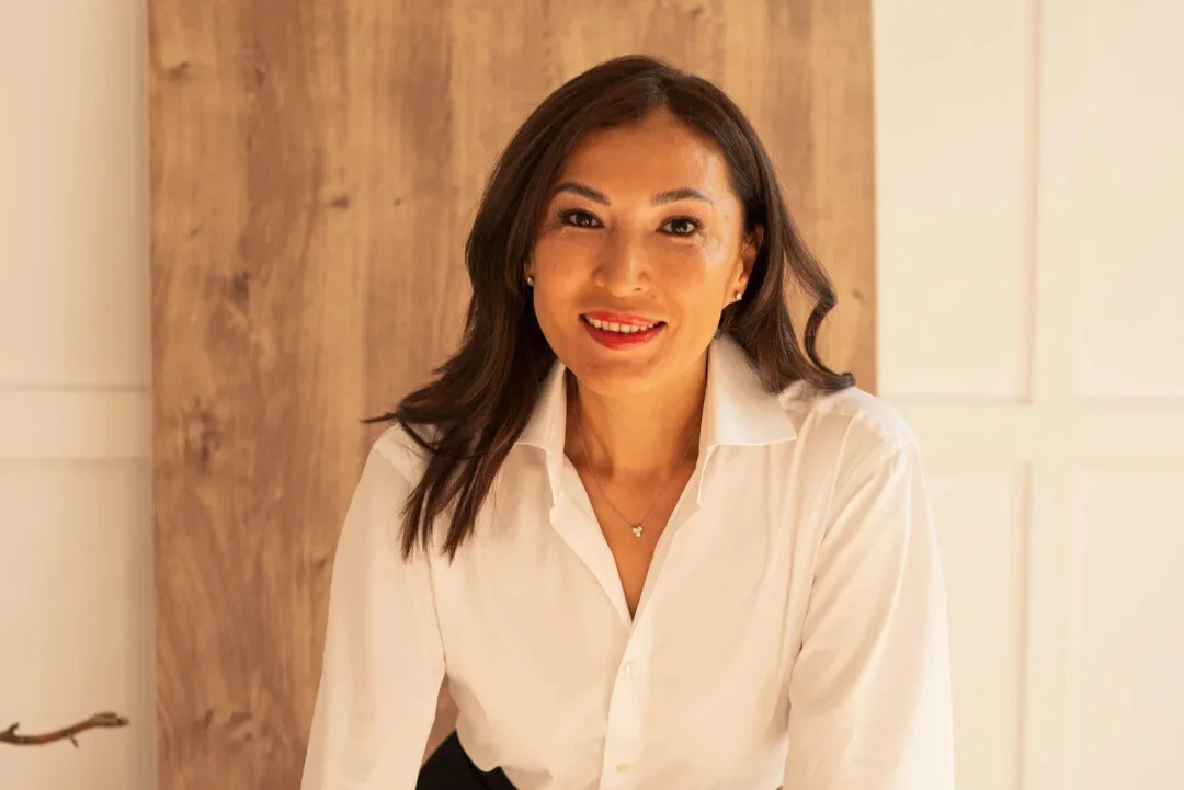 Smiling woman in white shirt posing indoors