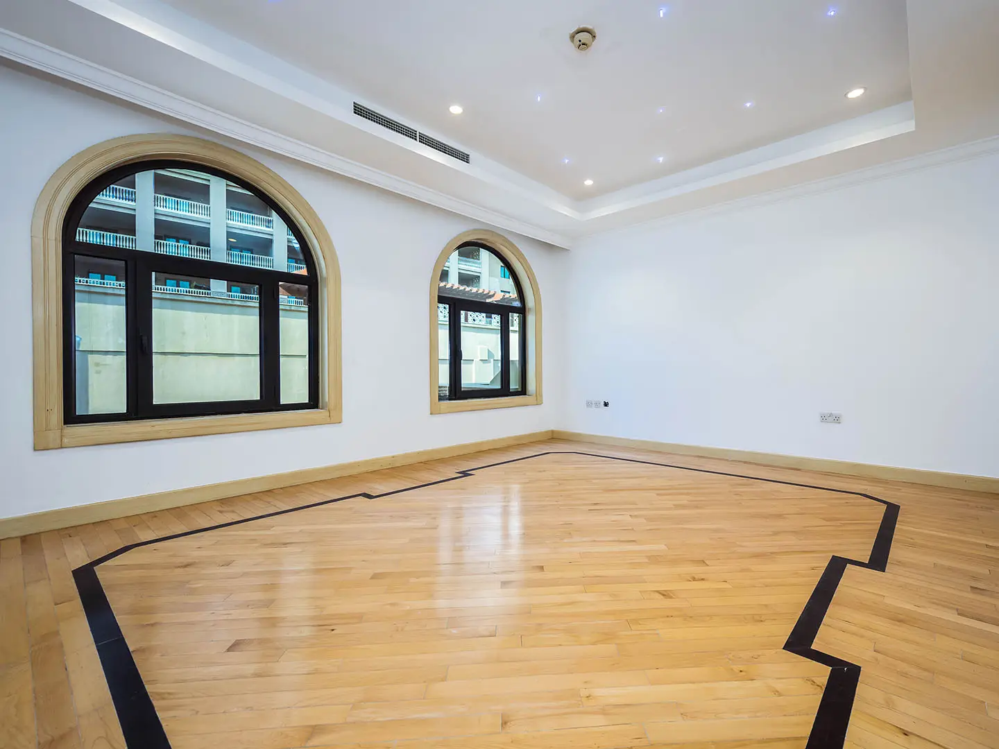 Empty room with arched windows and wooden floor