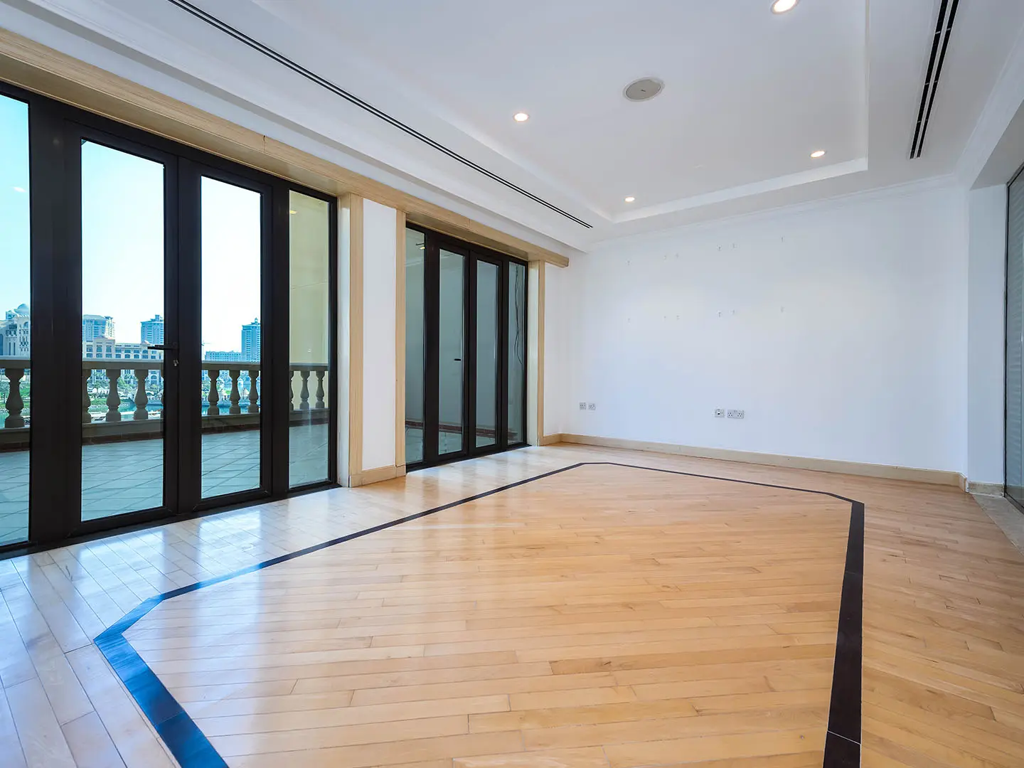 Empty room with wooden floor and large glass doors