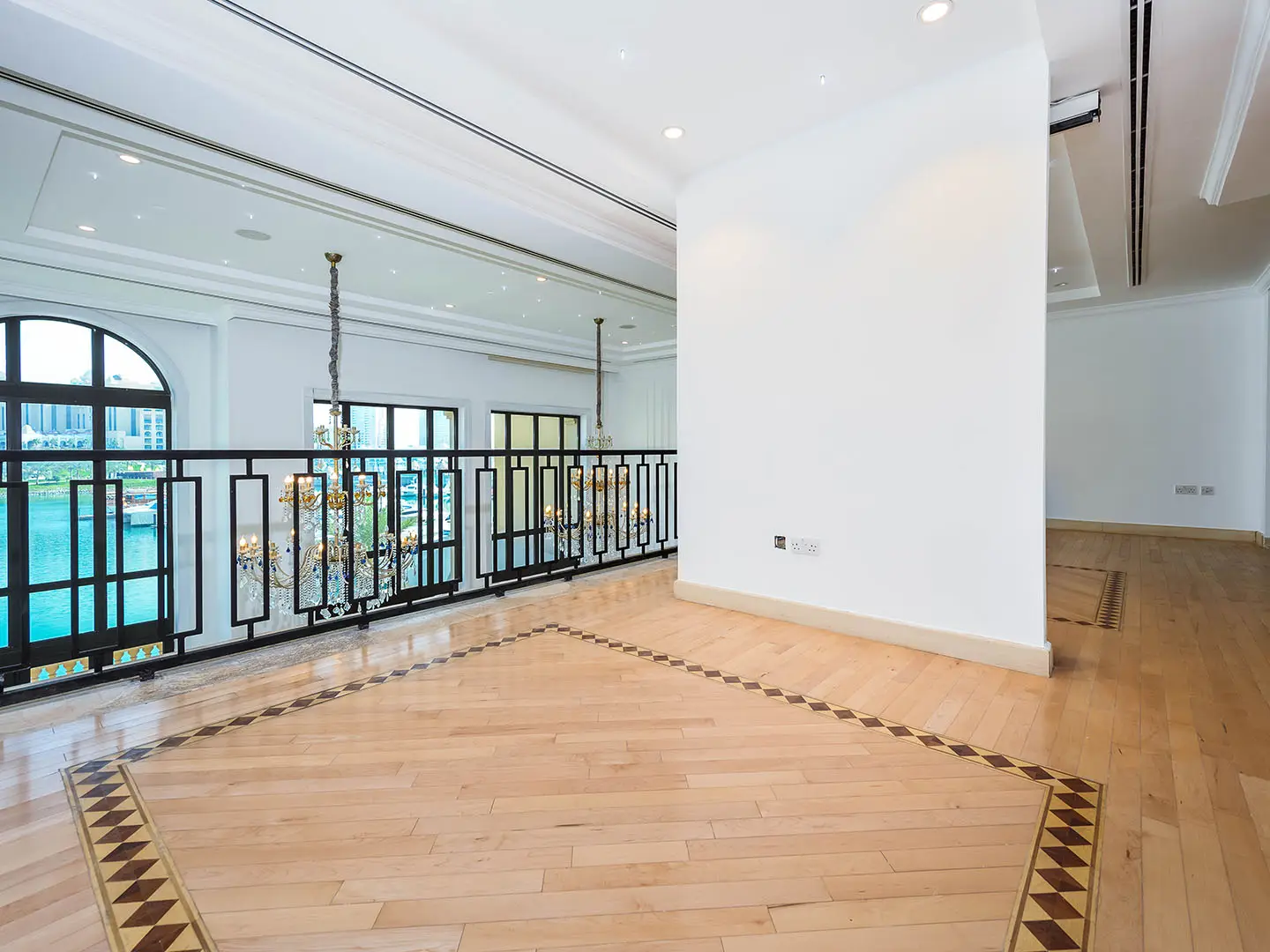 Empty upper floor with railing overlooking chandelier