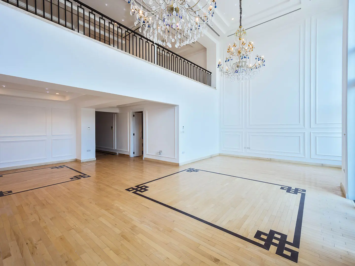 Bright spacious room with chandelier and balcony view.