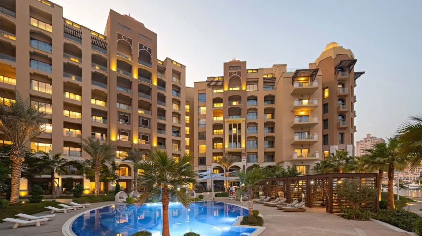 Apartment complex with glowing pool at dusk