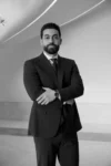 Professional man in suit posing confidently indoors.