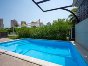 Blue pool near greenery and city towers view
