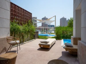 Shaded outdoor patio with pool and skyline