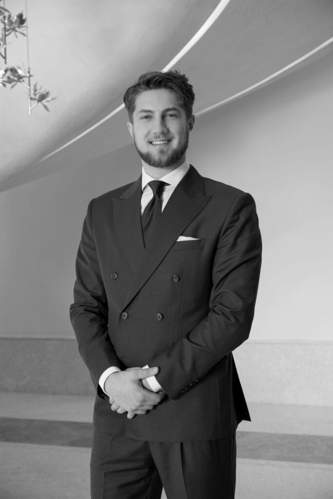 Professional man in suit standing indoors smiling