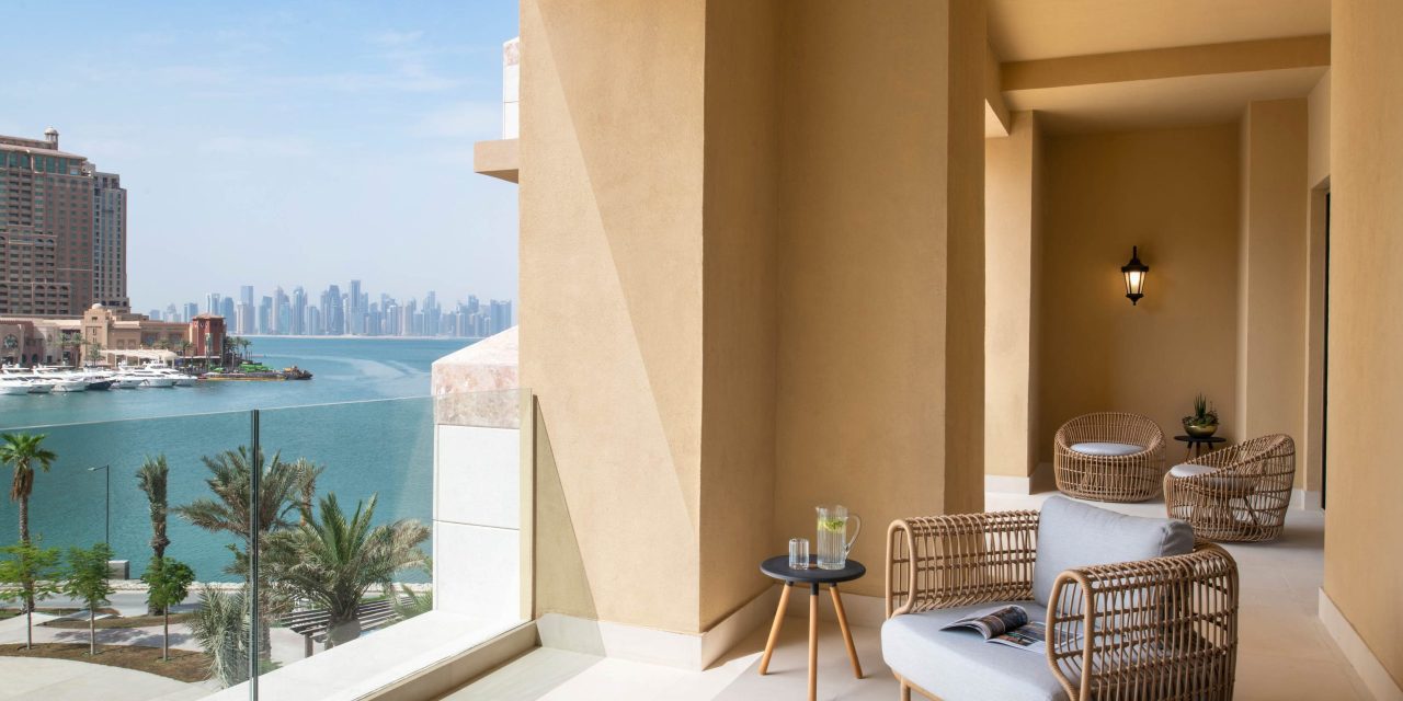 Hotel balcony with chairs, table, and ocean view