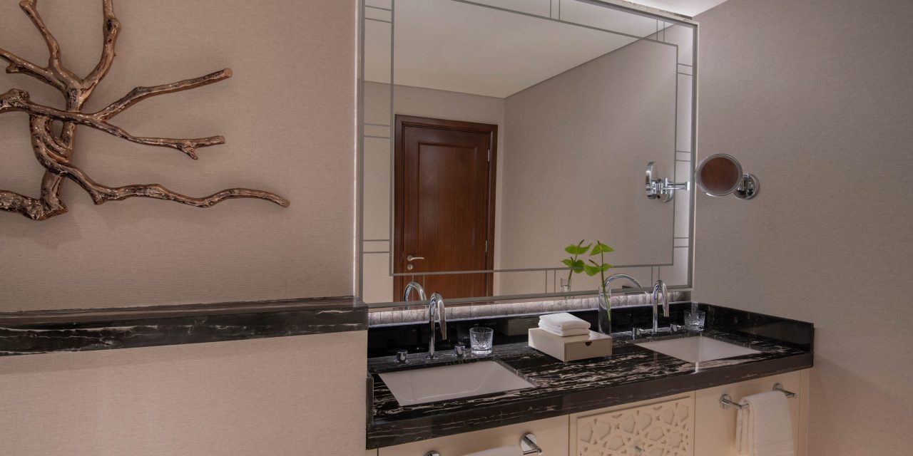 Bathroom with a double sink, black marble counter